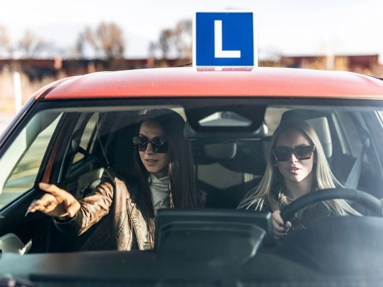 Instruktorka i kursantka podczas nauki parkowania prostopadłego tyłem