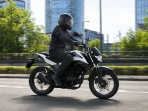 Motocyklista jadący motocyklem 125 cm³ po moście w Warszawie