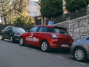 Auto nauki jazdy GAZeLka zaparkowane na wzniesieniu między innymi samochodami