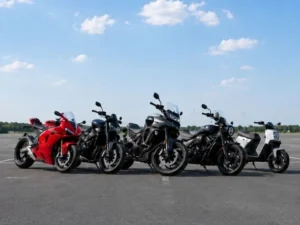 Różne rodzaje motocykli ustawione na placu: motocykl sportowy, miejski, turystyczny, cruiser oraz skuter jako przykład podstawowej klasyfikacji motocykli.