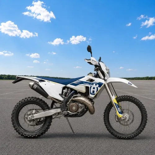 Motocykl terenowy enduro do jazdy poza asfaltem Biały motocykl terenowy enduro ustawiony bokiem na placu, przykład lekkiego motocykla z wysokim zawieszeniem i oponami kostkowymi do jazdy w terenie.