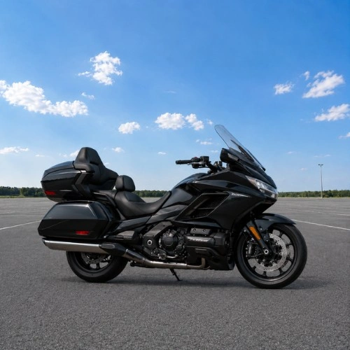 Motocykl turystyczny do długich tras Czarny motocykl turystyczny z wysoką szybą, kuframi i wygodnym siedzeniem, ustawiony bokiem na placu jako przykład motocykla do długich tras i komfortowej jazdy.